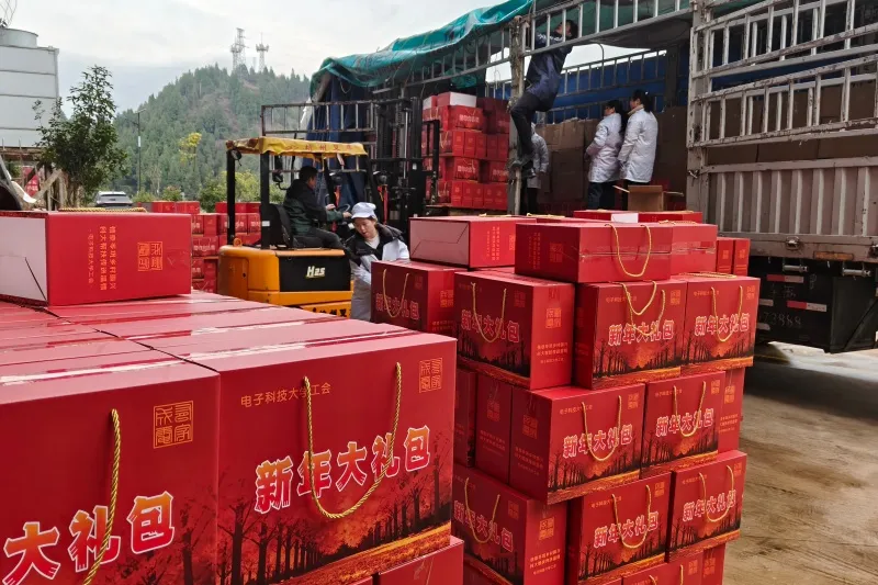 Рабочие загружают упакованные местные деликатесы в грузовик. (Фото Фэн Пяо)