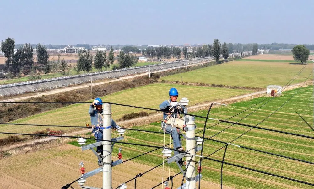 На фотографии изображены сотрудники Государственной электросетевой компании Цзяоцзо, выполняющие работы по модернизации системы автоматизации распределения электроэнергии на линии электропередачи напряжением 10 кВ (фото предоставлено собеседником).