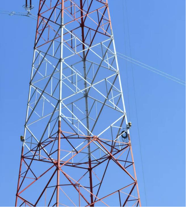 Крупный план установки трёхуровневых авиационных огней на одной опоре линии электропередачи